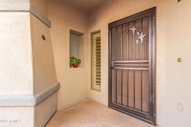 property entrance with stucco siding