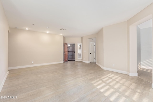 unfurnished room with light wood finished floors, recessed lighting, visible vents, and baseboards