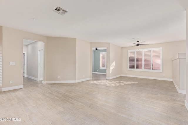 spare room featuring visible vents, ceiling fan, light wood-style flooring, and baseboards