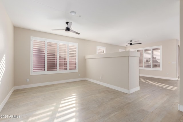 unfurnished room with light wood-style flooring, baseboards, and ceiling fan