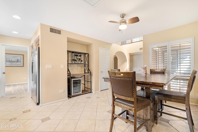 dining space featuring light tile patterned flooring, ceiling fan, and beverage cooler