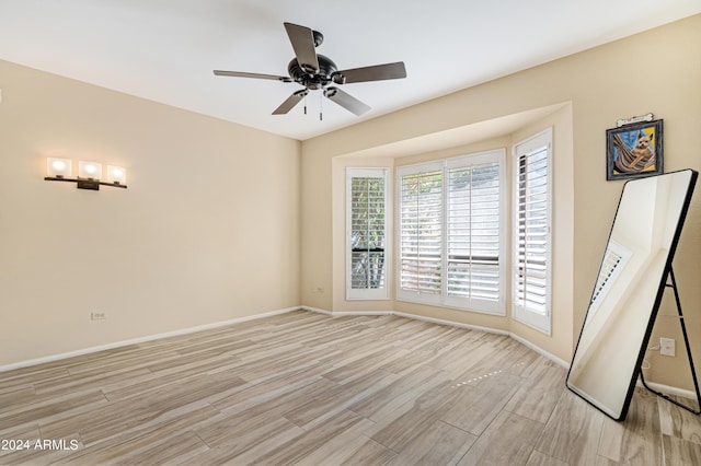 spare room with ceiling fan and light wood-type flooring