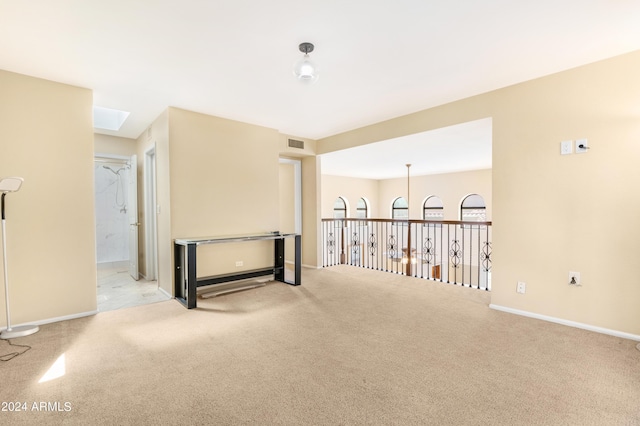 unfurnished room with light carpet and a skylight