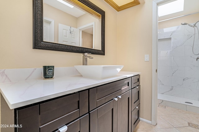 bathroom with vanity, a tile shower, and tile patterned floors