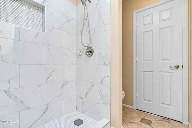 bathroom featuring tiled shower and toilet