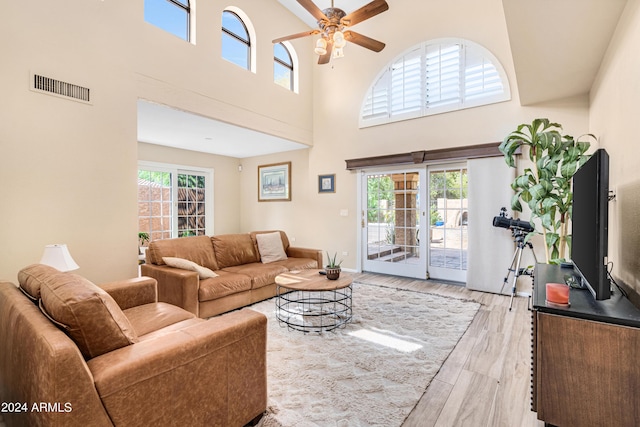 living room with light hardwood / wood-style flooring, ceiling fan, and plenty of natural light