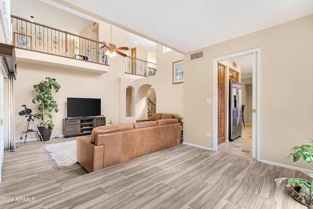 living room featuring light hardwood / wood-style flooring and ceiling fan