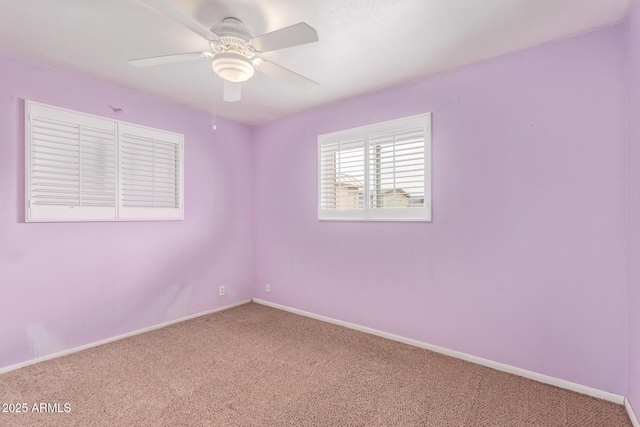 empty room featuring carpet floors, baseboards, and ceiling fan