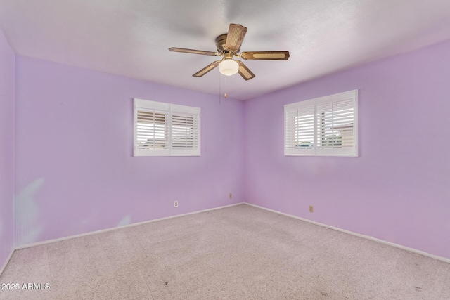 unfurnished room featuring carpet flooring, a ceiling fan, and baseboards