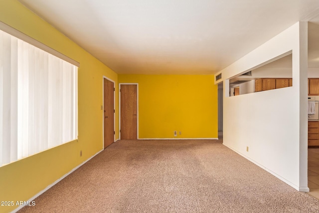 carpeted spare room with baseboards and visible vents
