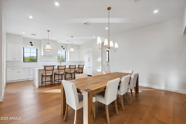 dining space featuring visible vents, a notable chandelier, recessed lighting, light wood finished floors, and baseboards