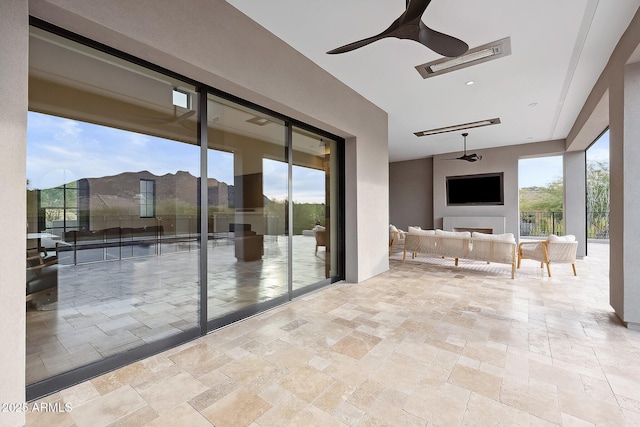 unfurnished sunroom with visible vents and a ceiling fan