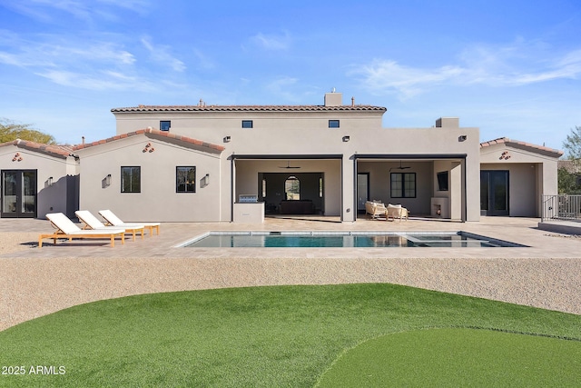 back of house with stucco siding, a tiled roof, a ceiling fan, and a patio