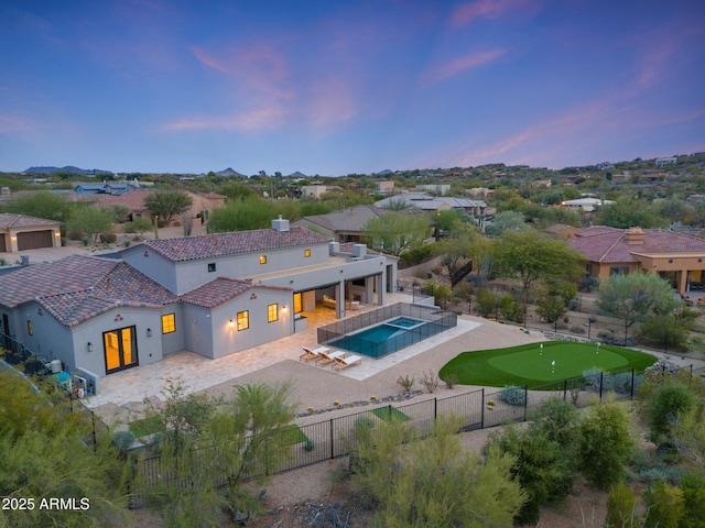 view of swimming pool with a residential view, a patio, a fenced backyard, and a pool with connected hot tub