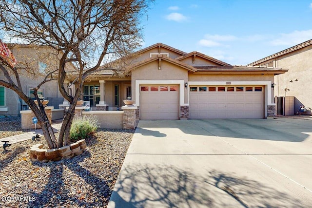 view of front of home with driveway, stone siding, an attached garage, and stucco siding