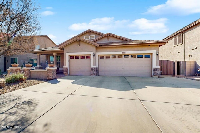 view of front of property featuring driveway, stone siding, an attached garage, a gate, and stucco siding