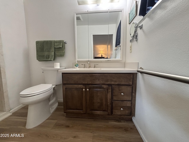 bathroom with vanity, hardwood / wood-style flooring, and toilet