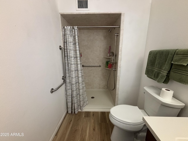 bathroom with vanity, hardwood / wood-style flooring, toilet, and walk in shower