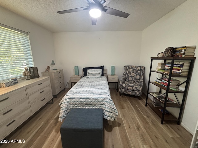 bedroom featuring ceiling fan, dark wood-type flooring, and a textured ceiling