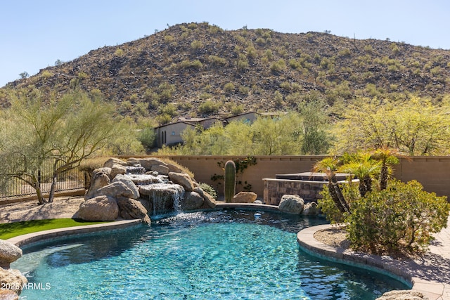 view of swimming pool with a mountain view and pool water feature