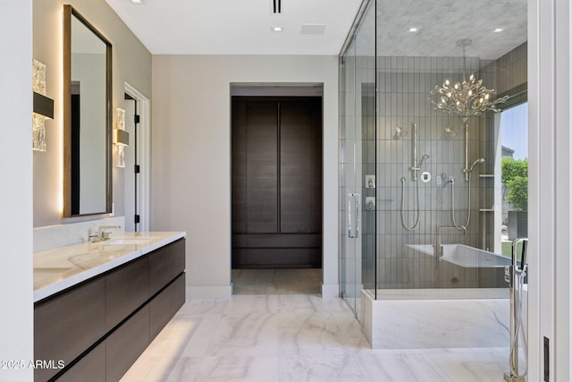 6908 E Cactus Wren Rd, Paradise Valley, AZ 85253 - bathroom featuring marble finish floors, a tub with marble appearance, double vanity, a stall shower, and a chandelier