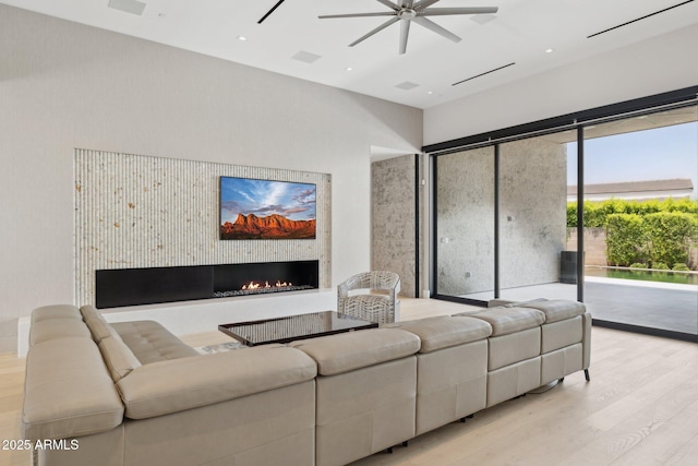 6908 E Cactus Wren Rd, Paradise Valley, AZ 85253 - living area featuring wood finished floors, ceiling fan, a warm lit fireplace, a towering ceiling, and recessed lighting