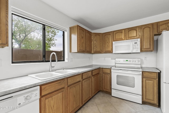 4404 W Ellis St, Laveen, AZ 85339 - kitchen featuring white appliances, a sink, brown cabinetry, light tile patterned floors, and light countertops