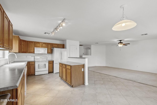 4404 W Ellis St, Laveen, AZ 85339 - kitchen featuring white appliances, a sink, ceiling fan, brown cabinetry, and a center island