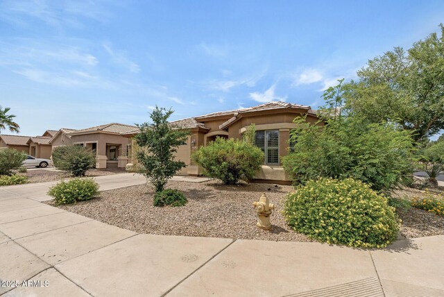 4404 W Ellis St, Laveen, AZ 85339 - view of front of house featuring stucco siding, driveway, a tiled roof, and a garage
