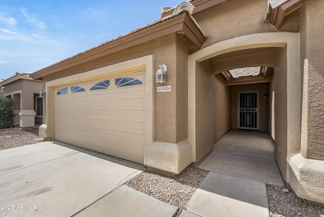 4404 W Ellis St, Laveen, AZ 85339 - property entrance featuring stucco siding, concrete driveway, and a garage