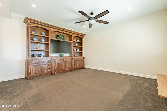 unfurnished living room with dark colored carpet and ceiling fan