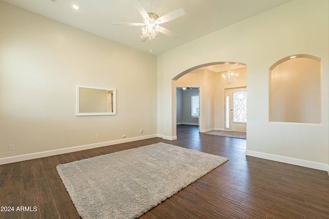 spare room featuring ceiling fan with notable chandelier and dark hardwood / wood-style flooring