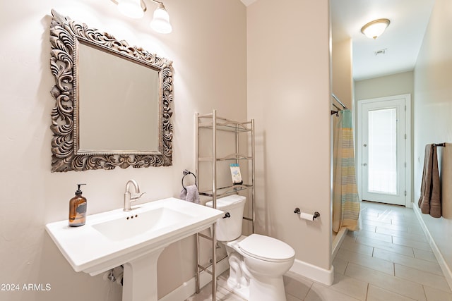 bathroom featuring tile patterned floors, a shower with curtain, sink, and toilet