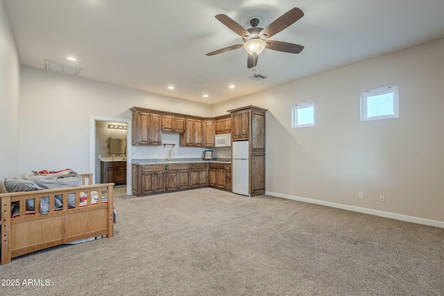 kitchen featuring ceiling fan, sink, white appliances, and light carpet