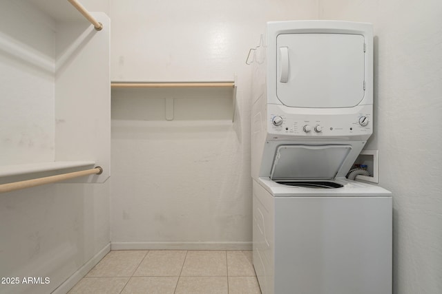 washroom featuring light tile patterned flooring and stacked washer and clothes dryer