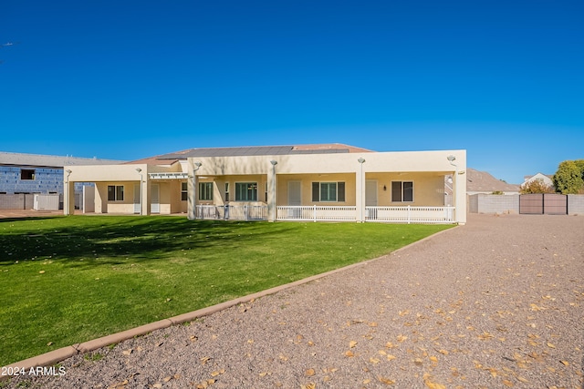 rear view of property featuring a pergola and a yard