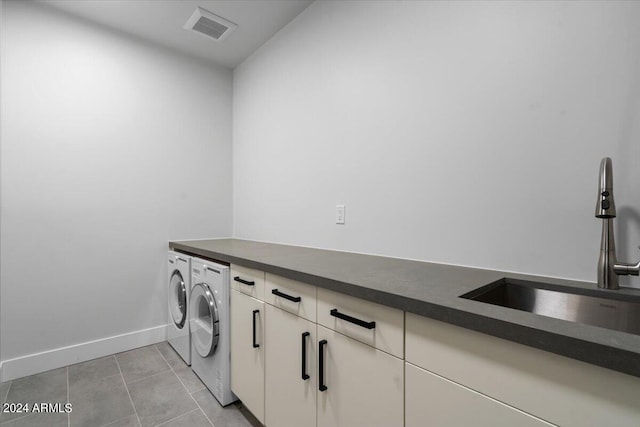 washroom with cabinets, separate washer and dryer, sink, and light tile patterned floors