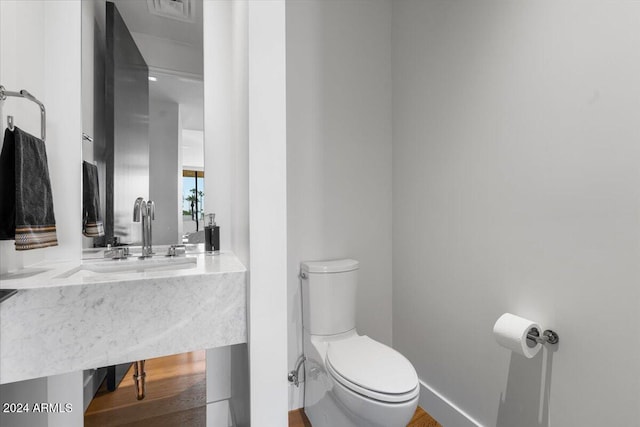 bathroom with toilet and hardwood / wood-style flooring