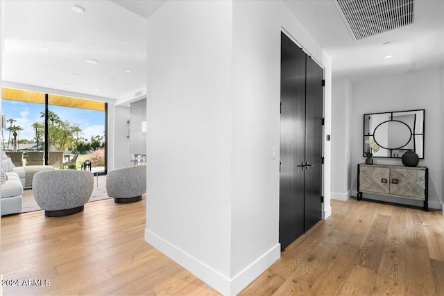 hall featuring expansive windows and light hardwood / wood-style floors