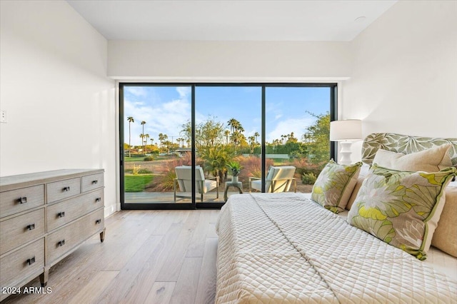 bedroom with access to exterior, light hardwood / wood-style flooring, and multiple windows