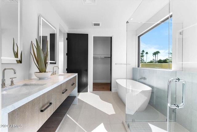 bathroom featuring tile patterned flooring, vanity, and shower with separate bathtub