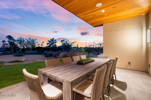 6311 E Phoenician Blvd Unit 21, Scottsdale, AZ 85251 - patio terrace at dusk with outdoor dining space, a patio, and a lawn