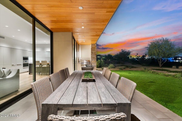 patio terrace at dusk featuring exterior kitchen