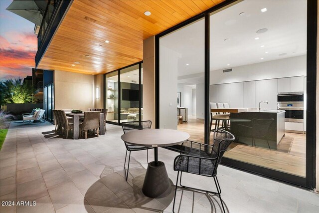 patio terrace at dusk featuring a wet bar