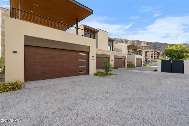 6311 E Phoenician Blvd Unit 21, Scottsdale, AZ 85251 - view of front of property featuring a balcony, stucco siding, an attached garage, a mountain view, and stone siding