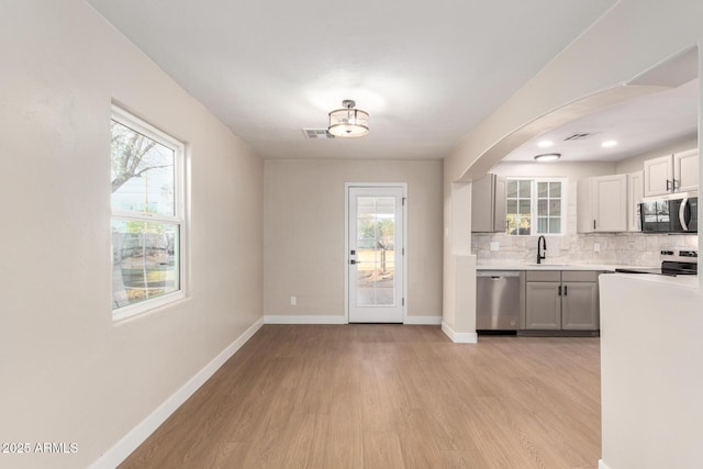 kitchen featuring visible vents, baseboards, light countertops, appliances with stainless steel finishes, and a sink