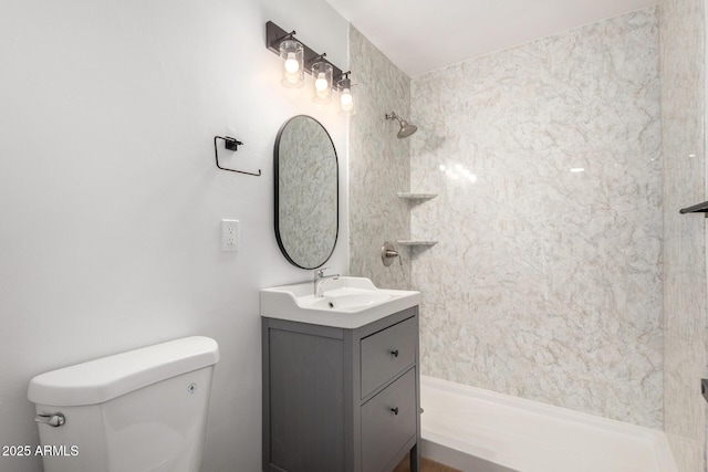 bathroom featuring a shower, toilet, and vanity