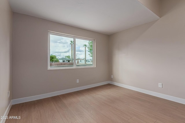 unfurnished room featuring light wood-type flooring and baseboards