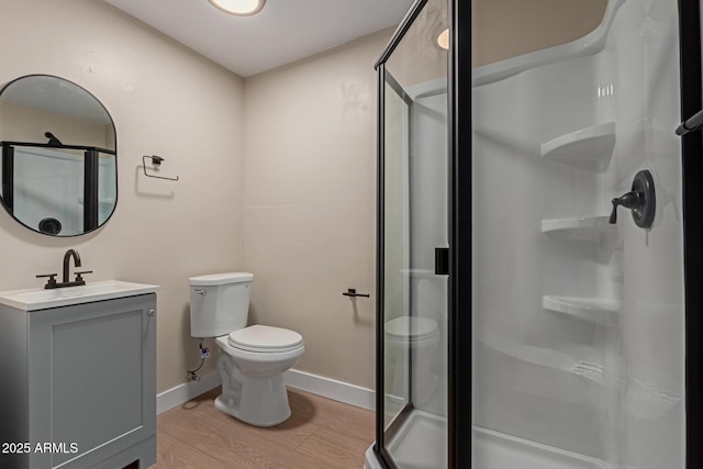 full bath featuring vanity, toilet, wood finished floors, and a shower stall