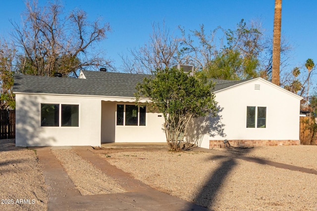 exterior space featuring stucco siding, a patio, roof with shingles, and fence